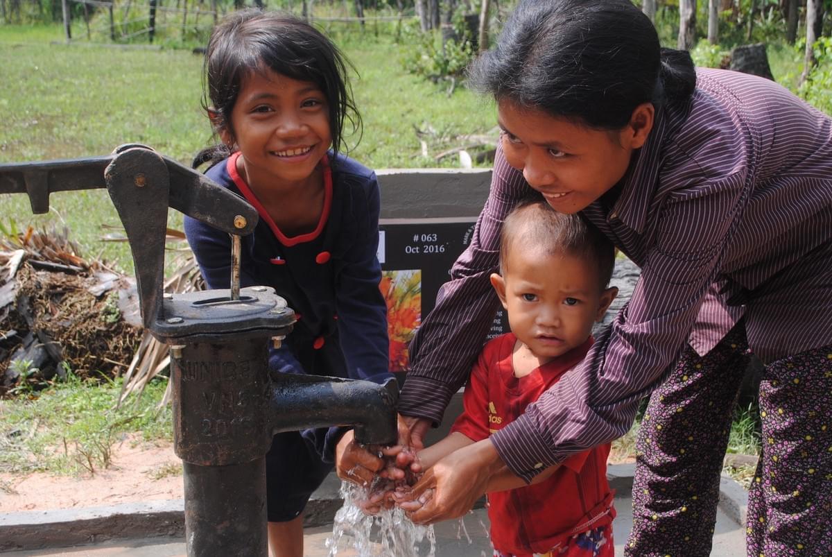 A Grateful Cambodian family enjoying water from a well donated by the Mark & Trina Ramsey Foundation