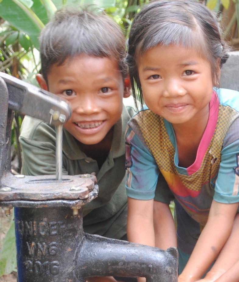 Cambodian children smiling appreciatively after their family received Well #65, donated by MTRF