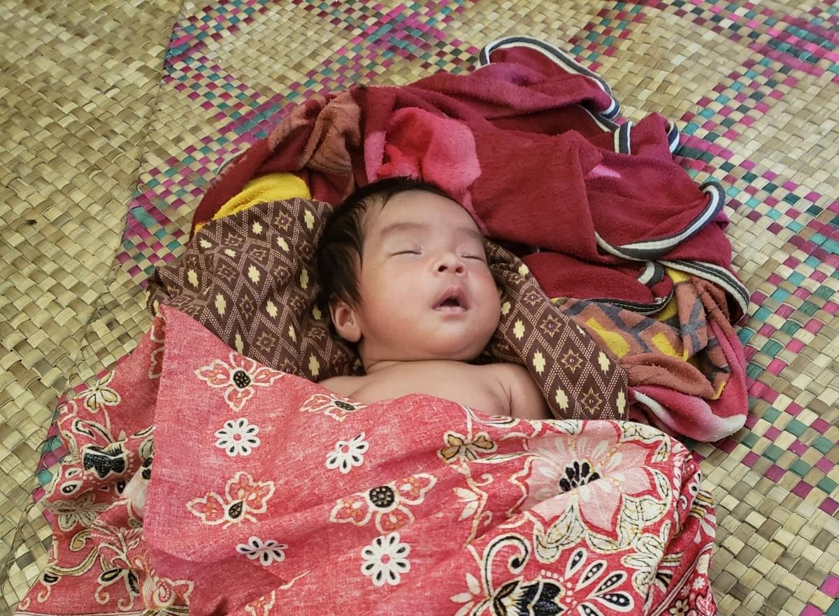 Precious Cambodian newborn resting comfortably in home constructed with supplies donated by MTRF