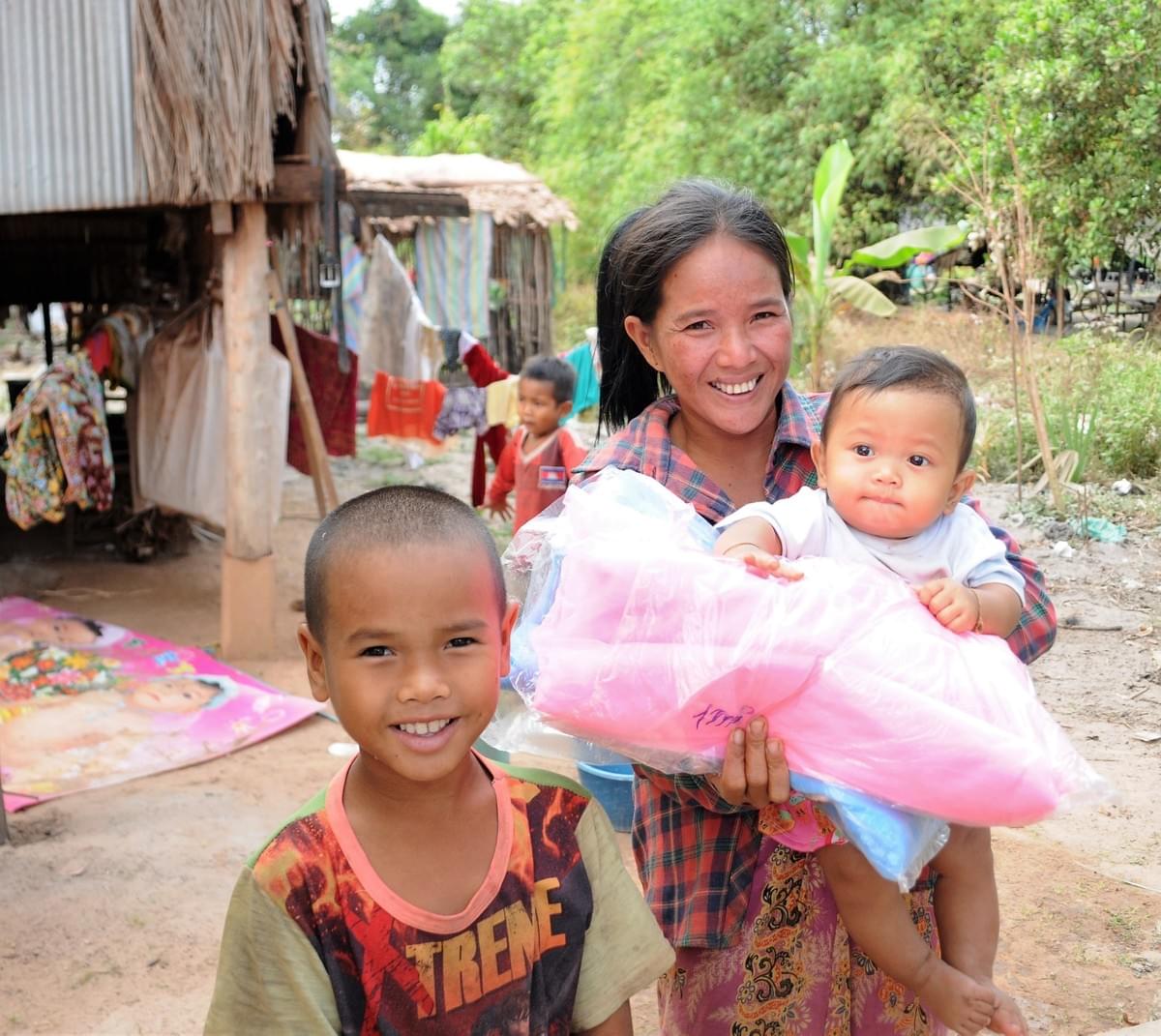 A mother & young children in Cambodia gratefully accept mosquito nets to aid in protecting them from Malaria (donated by MTRF)